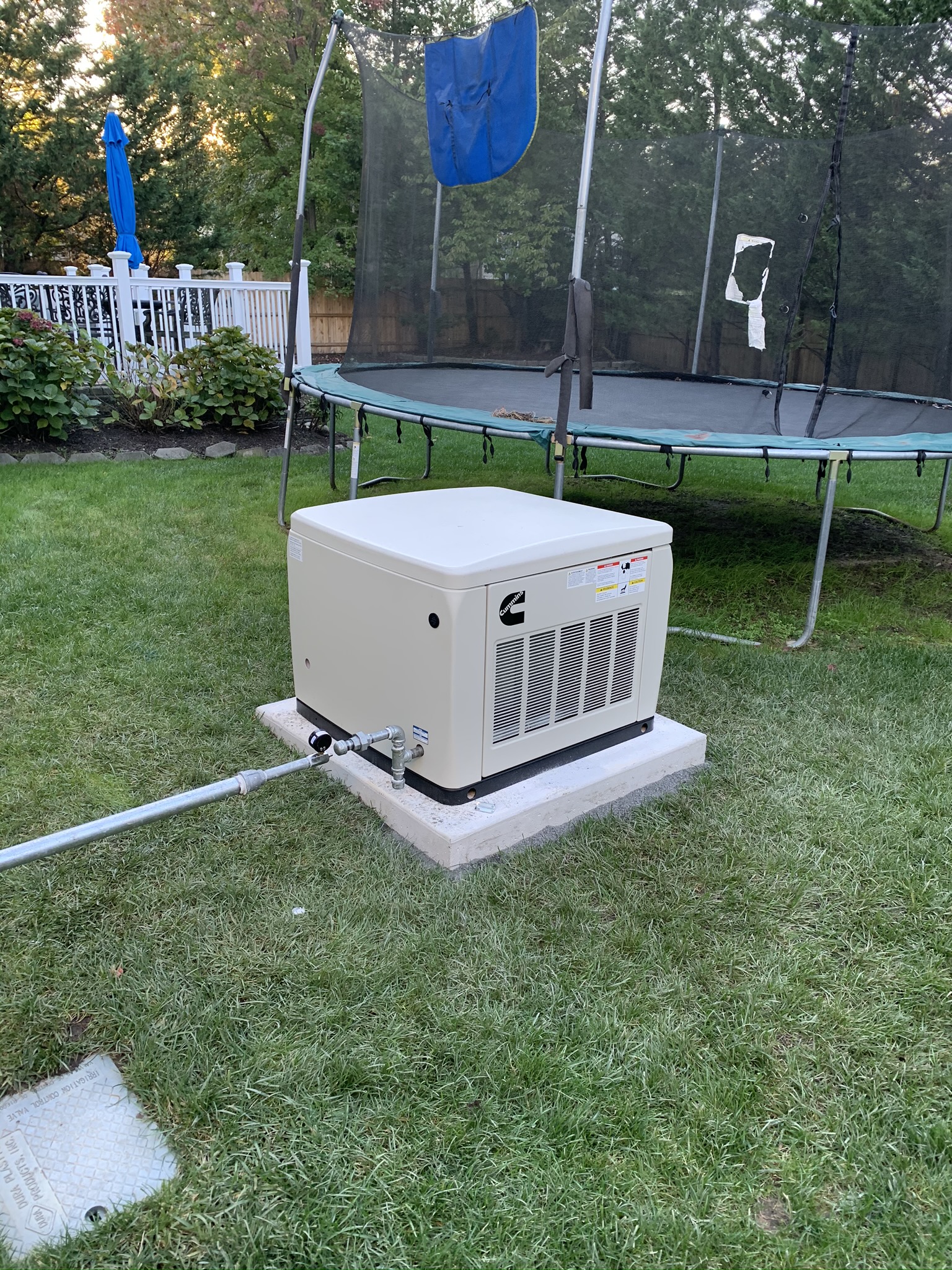 whole house backup generator installation project in back yard next to trampoline