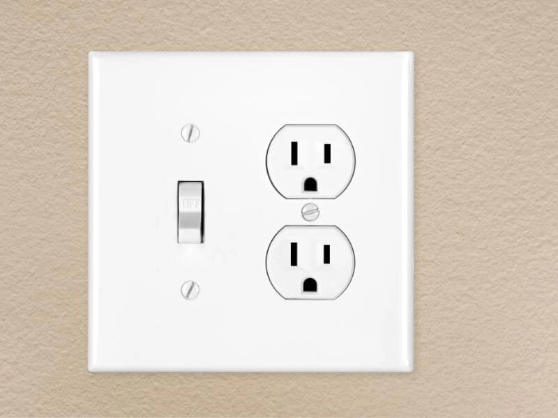 white light switch and electrical outlets on beige wall